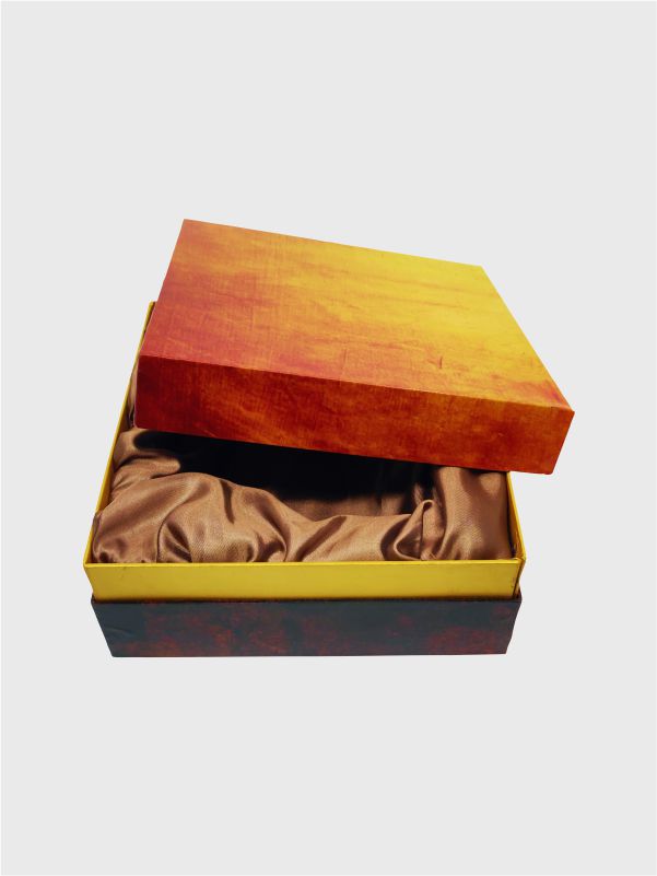 Rigid box with lid leaning on base showing golden satin-lined thermocol tray inside