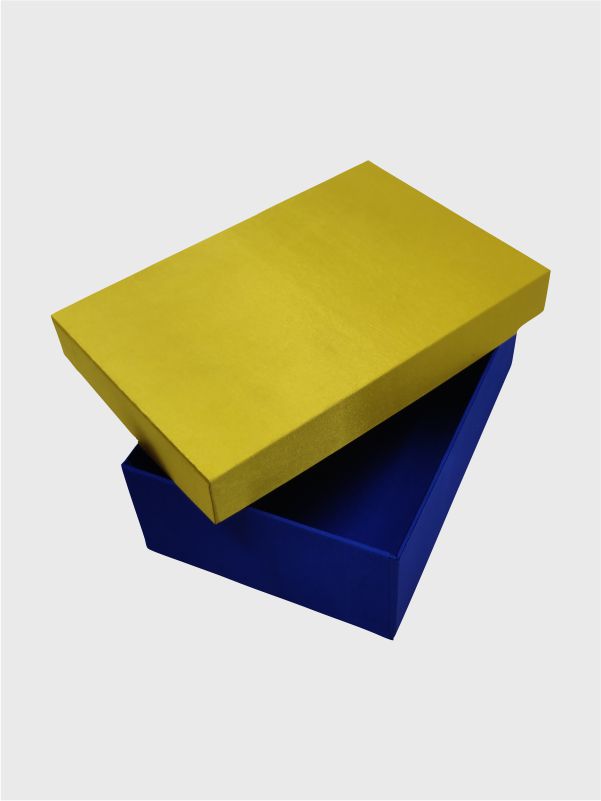 Golden lid placed diagonally on dark blue kappa gift box base wrapped in satin fabric
